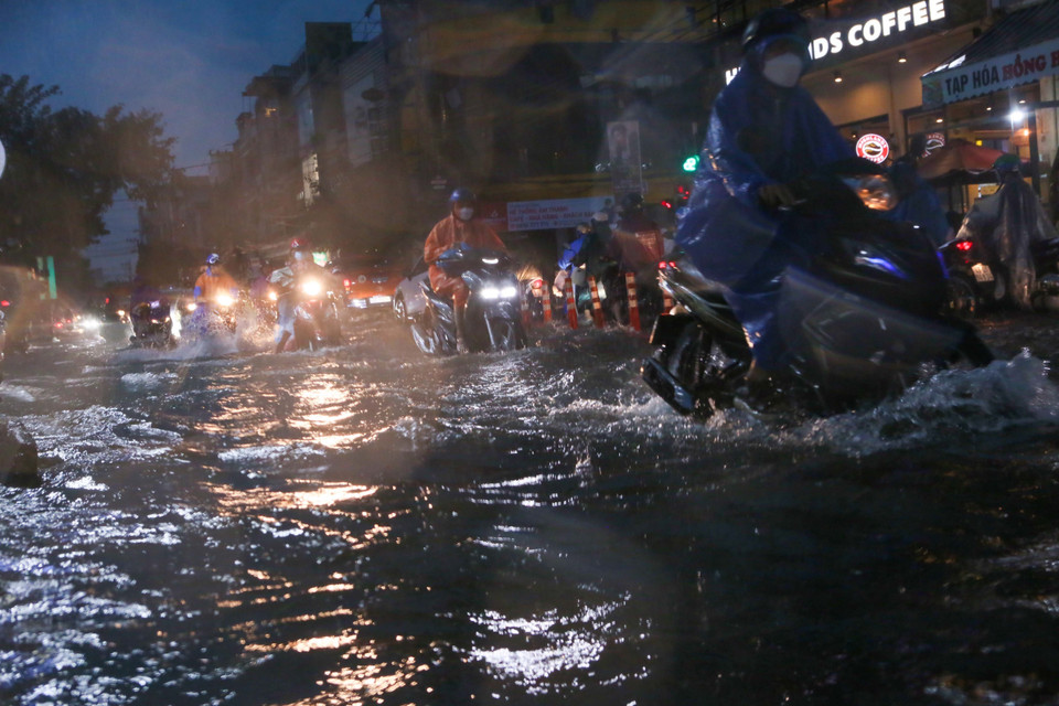 Đường Hùng Vương ngập sâu trong nước, gây khó khăn cho các phương tiện lưu thông. (Ảnh: Trần Lê Lâm/TTXVN)