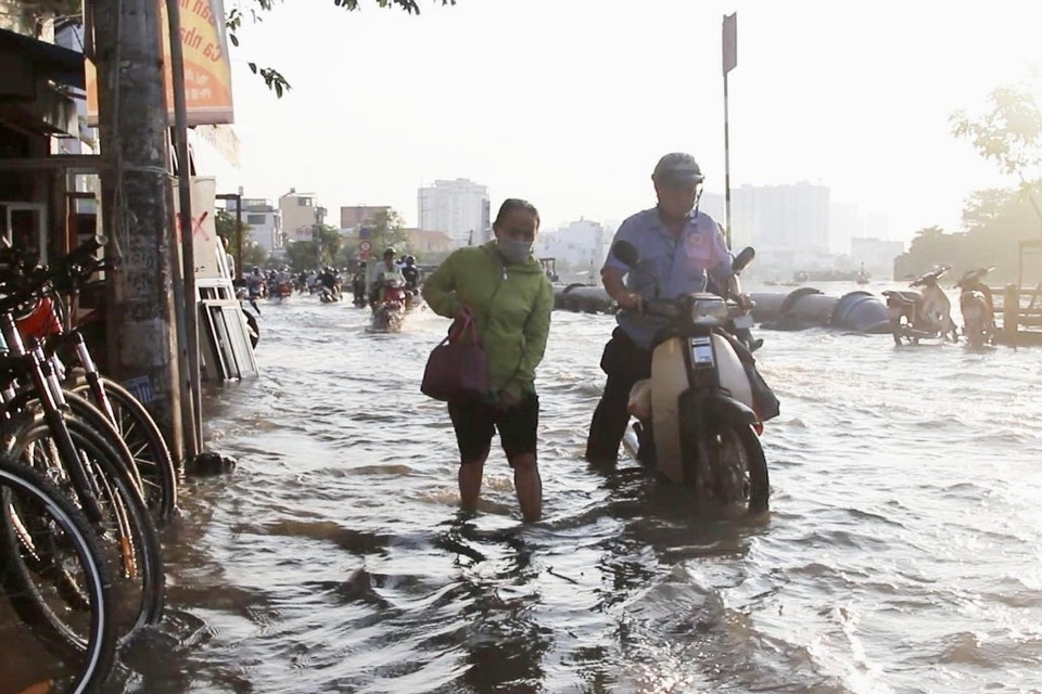 Người dân vất vả di chuyển trên đường Trần Xuân Soạn, quận 7.(Ảnh: Thanh Vũ/TTXVN)