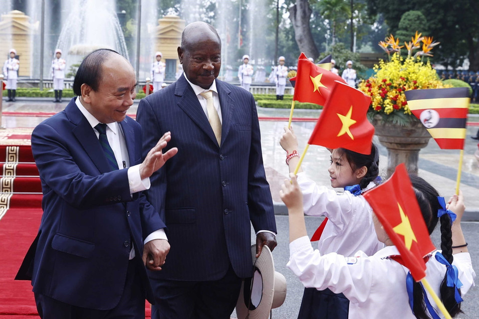 Chủ tịch nước Nguyễn Xuân Phúc và Tổng thống Uganda Yoweri Kaguta Museve với thiếu nhi Hà Nội tại lễ đón. (Ảnh: Thống Nhất/TTXVN)