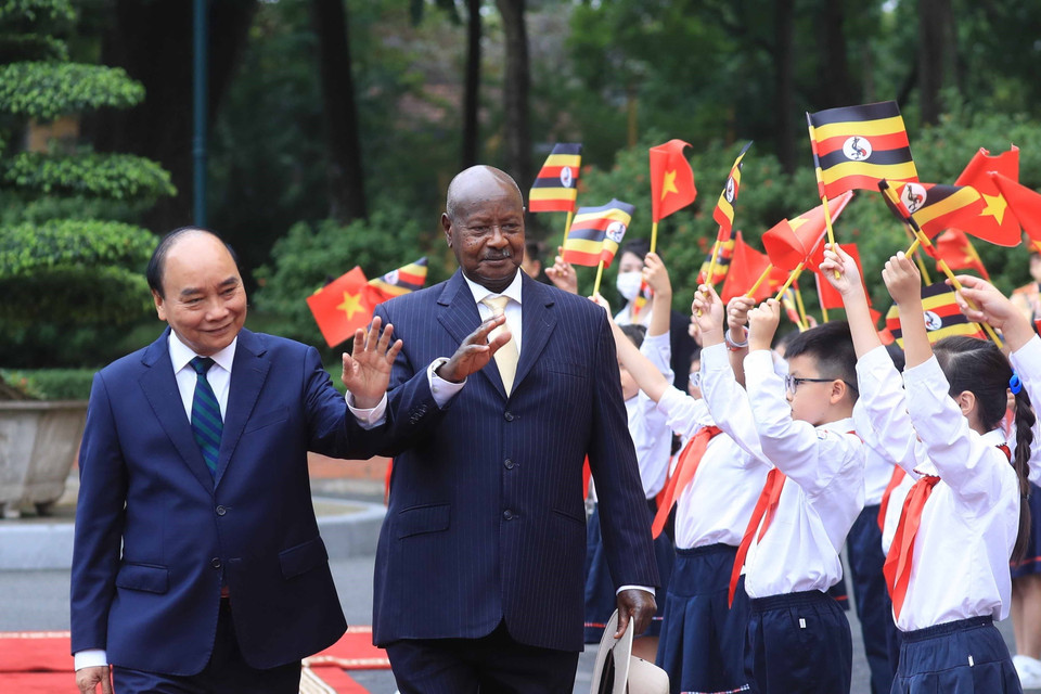 Chủ tịch nước Nguyễn Xuân Phúc và Tổng thống Uganda Yoweri Kaguta Museve với thiếu nhi Hà Nội tại lễ đón. (Ảnh: Thống Nhất/TTXVN)