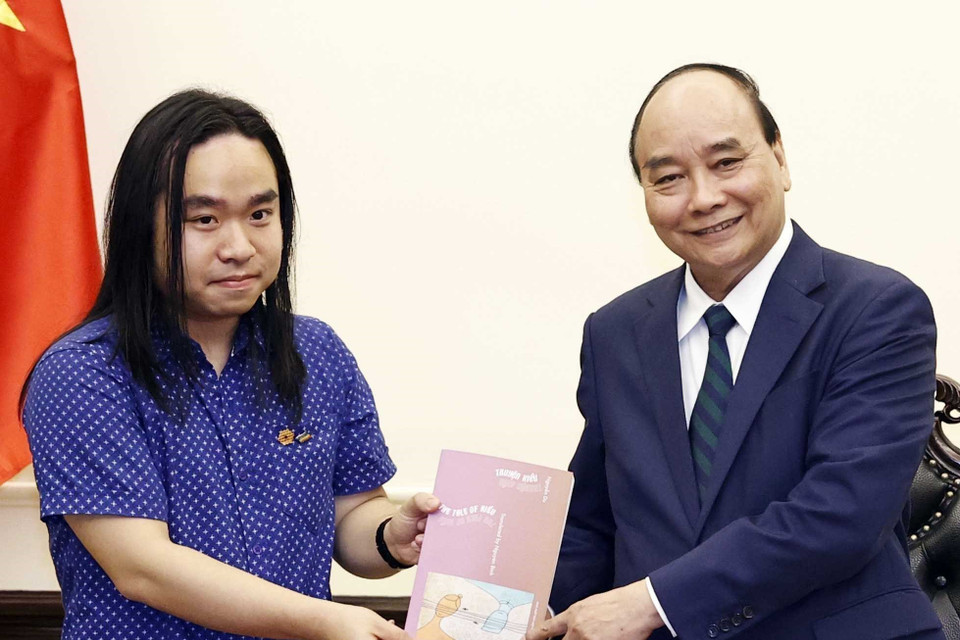 Dịch giả trẻ Nguyễn Bình tặng Chủ tịch nước Nguyễn Xuân Phúc tác phẩm 'Truyện Kiều' song ngữ. (Ảnh: Thống Nhất/TTXVN)