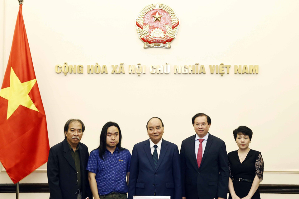 Chủ tịch nước Nguyễn Xuân Phúc gặp tài năng văn học trẻ Nguyễn Bình. (Ảnh: Thống Nhất/TTXVN)