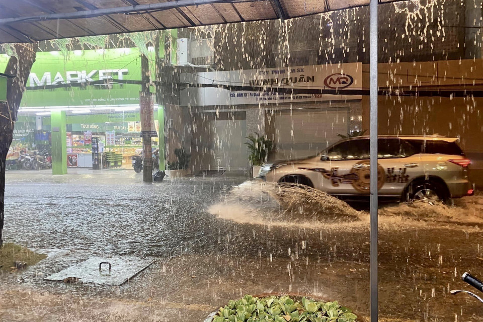 Nước ngập gần nửa bánh xe hơi trên đường Linh Đông, thành phố Thủ Đức. (Ảnh: Hồng Giang/TTXVN)