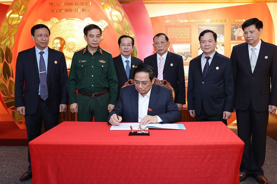 Thủ tướng Phạm Minh Chính viết lưu bút sau khi thăm Phòng truyền thống Hội Cựu chiến binh Việt Nam. (Ảnh: Dương Giang/TTXVN)