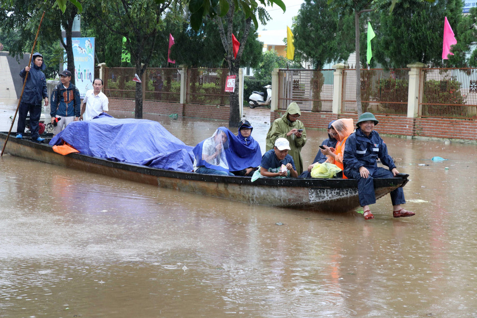 Người dân thị trấn Lao Bảo, Hướng Hóa, Quảng Trị dùng thuyền di chuyển đồ dùng tránh lũ. (Ảnh: Nguyên Lý/TTXVN)