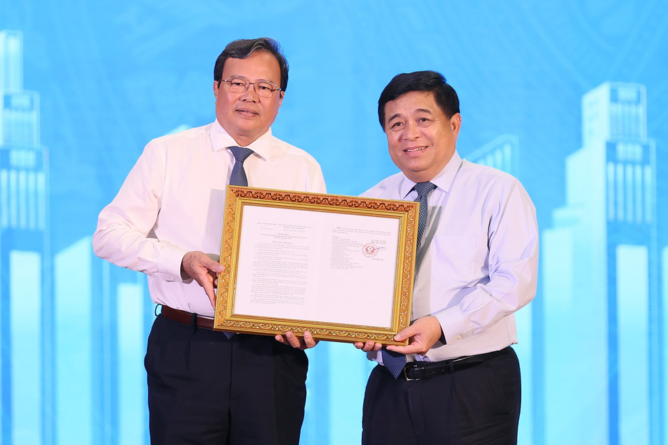 Bộ trưởng Bộ Kế hoạch và Đầu tư Nguyễn Chí Dũng trao Quyết định Quy hoạch tỉnh Trà Vinh cho lãnh đạo tỉnh. (Ảnh: Dương Giang/TTXVN)