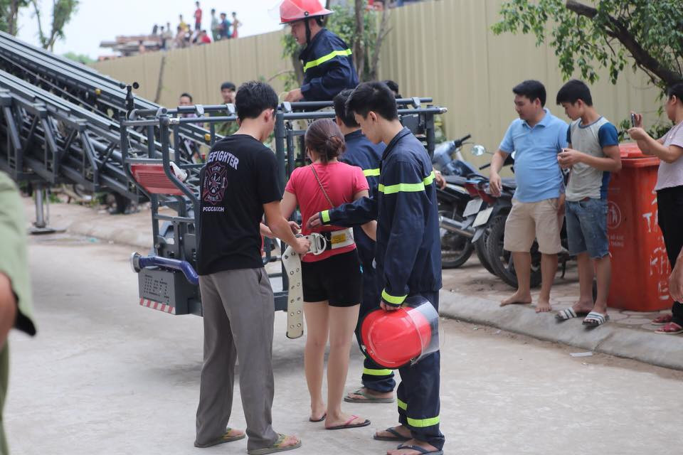 Một nạn nhân bị mắc kẹt trên tầng cao được xe thang giải cứu, đưa xuống đất an toàn. (Ảnh: PV/Vietnam+)