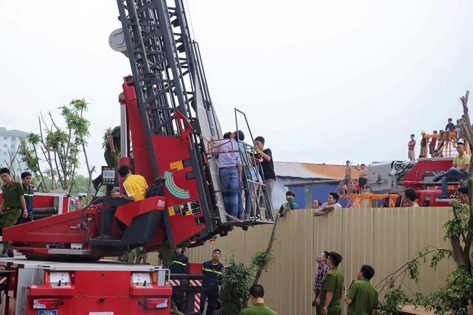 Đám đông hiếu kỳ đứng xem giải cứu những người bị mắc kẹt trên cao. (Ảnh: Minh Sơn/Vietnam+)