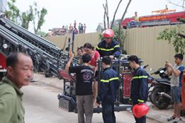 Một nạn nhân bị mắc kẹt trên tầng cao được xe thang giải cứu, đưa xuống đất an toàn. (Ảnh: PV/Vietnam+)