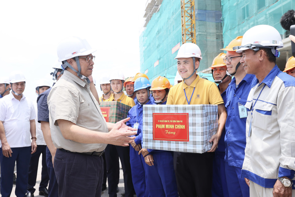 Thủ tướng Phạm Minh Chính tặng quà cho công nhân thi công khu nhà ở xã hội. (Ảnh: Dương Giang/TTXVN)