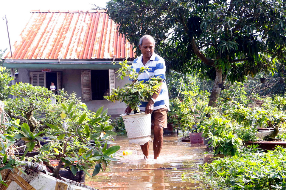 Người dân Cồn Khương di chuyển đồ đạc ra khỏi nơi bị ngập sâu. (Ảnh: Thanh Liêm/TTXVN)