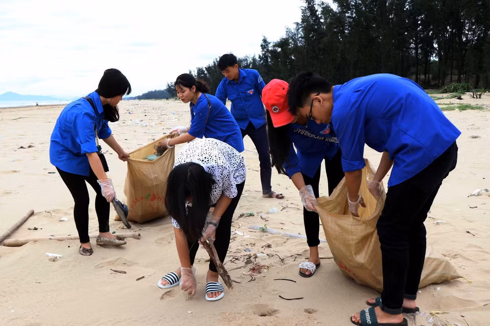 Lực lượng đoàn viên, thanh niên huyện Thạch Hà, tỉnh Hà Tĩnh thu gom rác trên bãi biển xã Thạch Hải. (Ảnh: Công Tường/TTXVN)