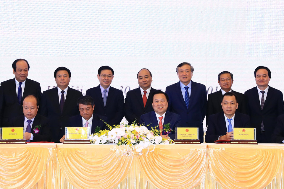 Thủ tướng Nguyễn Xuân Phúc và các đại biểu chứng kiến Lễ ký kết biên bản ghi nhớ giữa Ủy ban quản lý vốn nhà nước tại doanh nghiệp và 5 Bộ về kế hoạch chuyển giao các công việc và chuyển giao hồ sơ các doanh nghiệp về Ủy ban. (Ảnh: Thống Nhất/TTXVN)