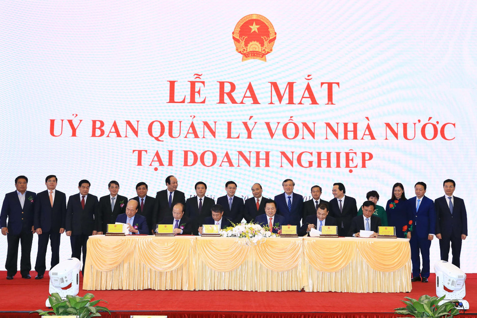 Thủ tướng Nguyễn Xuân Phúc và các đại biểu chứng kiến Lễ ký kết biên bản ghi nhớ giữa Ủy ban quản lý vốn nhà nước tại doanh nghiệp và 5 Bộ về kế hoạch chuyển giao các công việc và chuyển giao hồ sơ các doanh nghiệp về Ủy ban. (Ảnh: Thống Nhất/TTXVN)