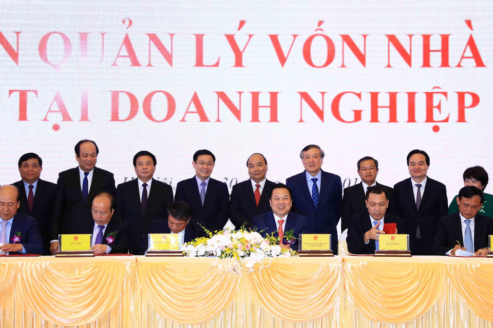 Thủ tướng Nguyễn Xuân Phúc và các đại biểu chứng kiến Lễ ký kết biên bản ghi nhớ giữa Ủy ban quản lý vốn nhà nước tại doanh nghiệp và 5 Bộ về kế hoạch chuyển giao các công việc và chuyển giao hồ sơ các doanh nghiệp về Ủy ban. (Ảnh: Thống Nhất/TTXVN)