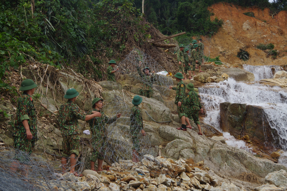 Lực lượng cứu hộ vận chuyển rọ đá để thực hiện nhiệm vụ nắn dòng suối Rào Trăng. (Ảnh: TTXVN phát)