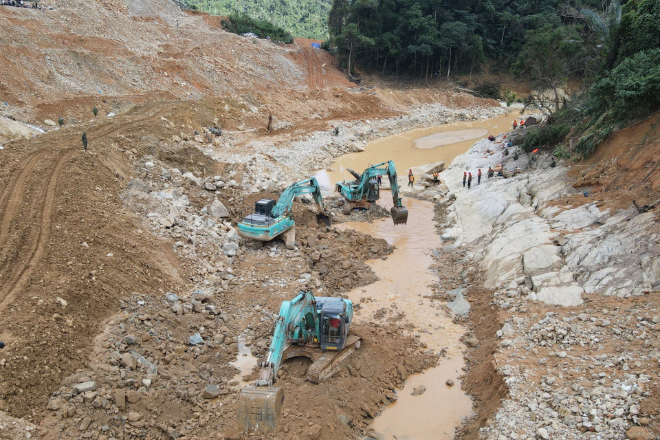 Lực lượng chức năng và các phương tiện tìm kiếm các nạn nhân mất tích dưới lòng suối Rào Trăng. (Ảnh: TTXVN phát)