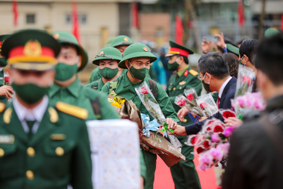 Buổi lễ giao nhận quân diễn ra nhanh chóng, các tân binh bước qua cổng vinh quang và nhận những đoá hoa từ các cấp ban ngành lãnh đạo quận, thành phố. (Ảnh: Minh Sơn/Vietnam+)