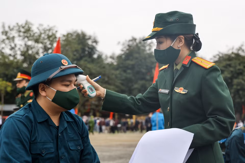 Các tân binh trước khi lên đường nhập ngũ được kiểm tra nhiệt độ lại một lần cuối. (Ảnh: Minh Sơn/Vietnam+)