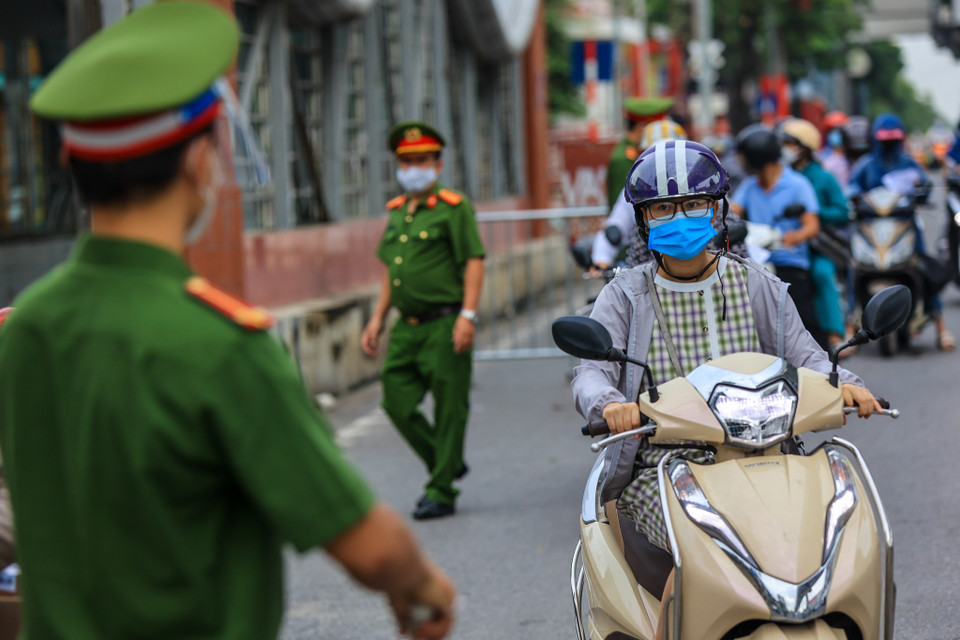 Tuy nhiên, hôm nay lực lượng chức năng chỉ nhắc nhở người dân về việc sử dụng mẫu giấy đi đường mới mà chưa xử phạt. (Ảnh: Minh Sơn/Vietnam+)