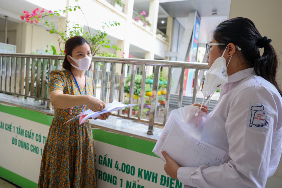 Thí sinh được tháo khẩu trang duy nhất khi được giám thị yêu cầu kiểm tra danh tính. (Ảnh: Minh Sơn/Vietnam+)