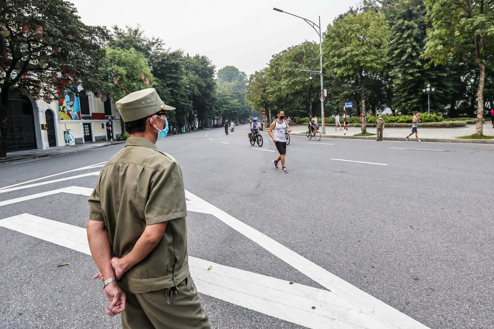 Lực lượng chức năng cũng tiến hành ra quân nhắc nhở người dân phải tuân thủ quy định như đeo khẩu trang, không tụ tập quá 10 người. (Ảnh: Minh Sơn/Vietnam+)