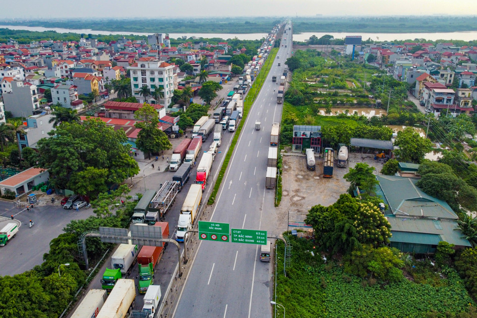 Tại chốt kiểm soát trên Quốc lộ 1A đoạn qua cầu Phù Đổng, Gia Lâm, các phương tiện được phân luồng từ xa, khi đến chốt kiểm soát xe 'luồng xanh' sẽ đi vào sát phía giải phân cách, còn các xe chưa có thẻ 'luồng xanh' được bố trí quay đầu ngay tại chốt kiểm soát. (Ảnh: Minh Sơn/Vietnam+)