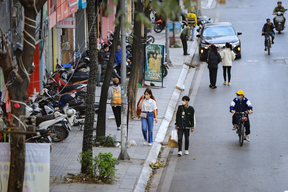 Hầu hết vỉa hè trên nhiều tuyến phố đều bị các hộ kinh doanh biến của công thành không gian buôn bán hoặc trông xe. Người đi bộ cực chẳng đã phải hòa mình vào dòng xe cộ dưới lòng đường. (Ảnh: Hoài Nam/Vietnam+)