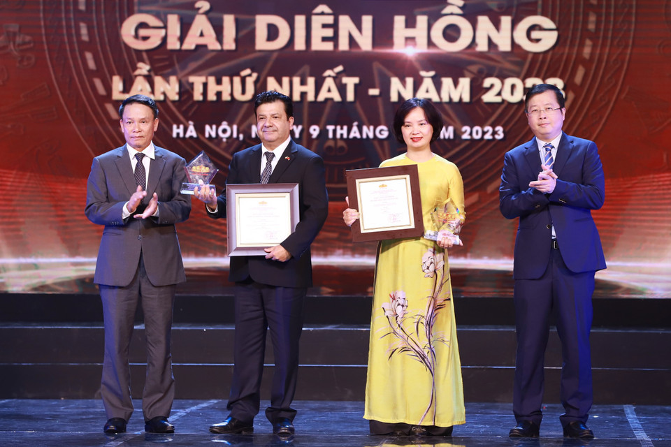 Ông Nguyễn Thanh Lâm, Thứ trưởng Bộ Thông tin và Truyền thông (bìa phải), ông Nguyễn Đức Lợi, Phó Chủ tịch Thường trực Hội Nhà báo Việt Nam (bìa trái) trao giải Sản phẩm đa phương tiện xuất sắc cho đại diện Thông tấn xã Việt Nam. (Ảnh: Hoài Nam/Vietnam+)