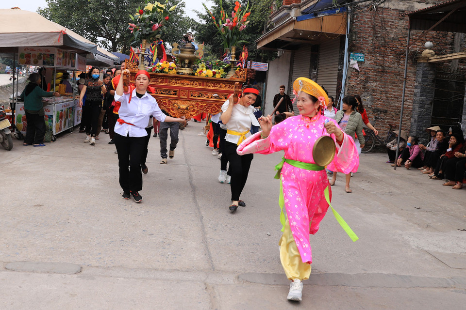 Trên đường rước kiệu từ đền Mẫu về đình làng, các đội khênh kiệu và hương án thi thoảng lại xoay kiệu hoặc khênh kiệu chạy đột ngột. Người dân nơi đây quan niệm rằng đó là do mẫu Đào Nương điều khiển. (Ảnh: Hoài Nam/Vietnam+)