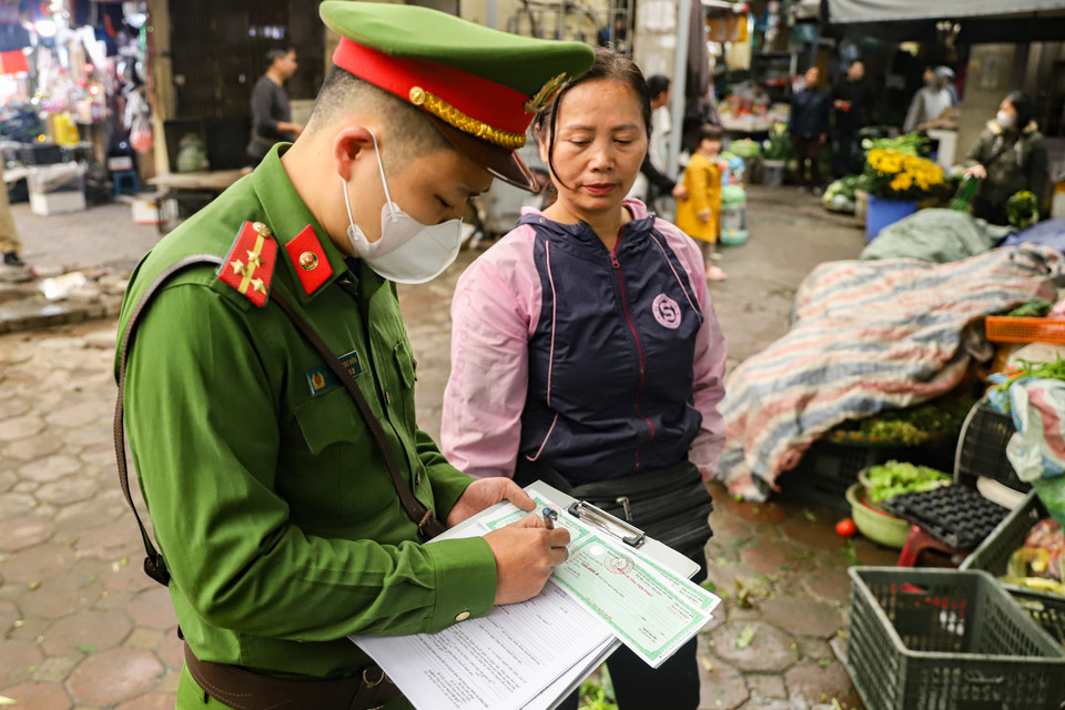Lực lượng chức năng tiến hành xử phạt hành chính 1 trường hợp vi phạm về đảm bảo trật tự văn minh đô thị tại khu vực chợ Thái Hà. (Ảnh: Hoài Nam/Vietnam+)
