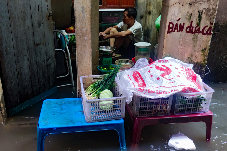 Người dân đã che chắn cửa nhà nhưng mưa quá lớn, mực nước tăng nhanh nên đành ‘sống chung với lũ’. (Ảnh: Hoài Nam/Vietnam+)