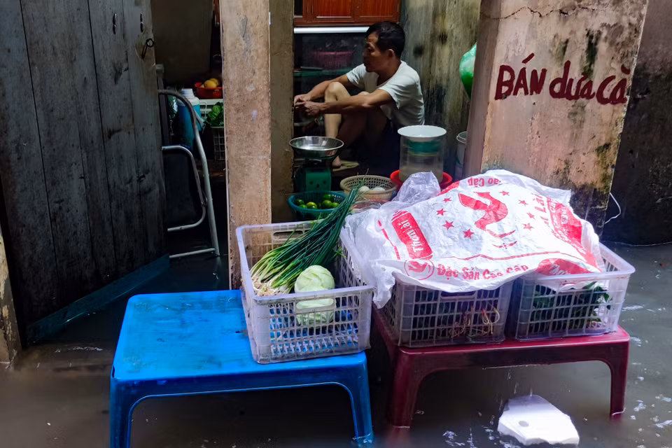 Người dân đã che chắn cửa nhà nhưng mưa quá lớn, mực nước tăng nhanh nên đành ‘sống chung với lũ’. (Ảnh: Hoài Nam/Vietnam+)