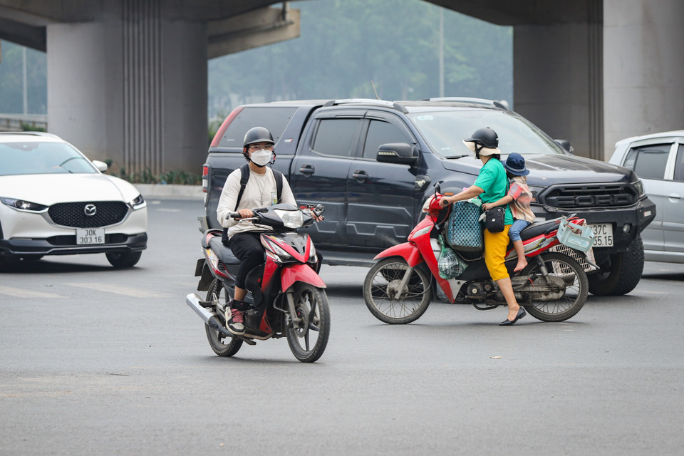 Có trường hợp mặc dù người cầm lái chở trẻ em phía sau nhưng vẫn bất chấp vượt đèn đỏ, băng qua luồng phương tiện đang di chuyển. (Ảnh: Hoài Nam/Vietnam+)