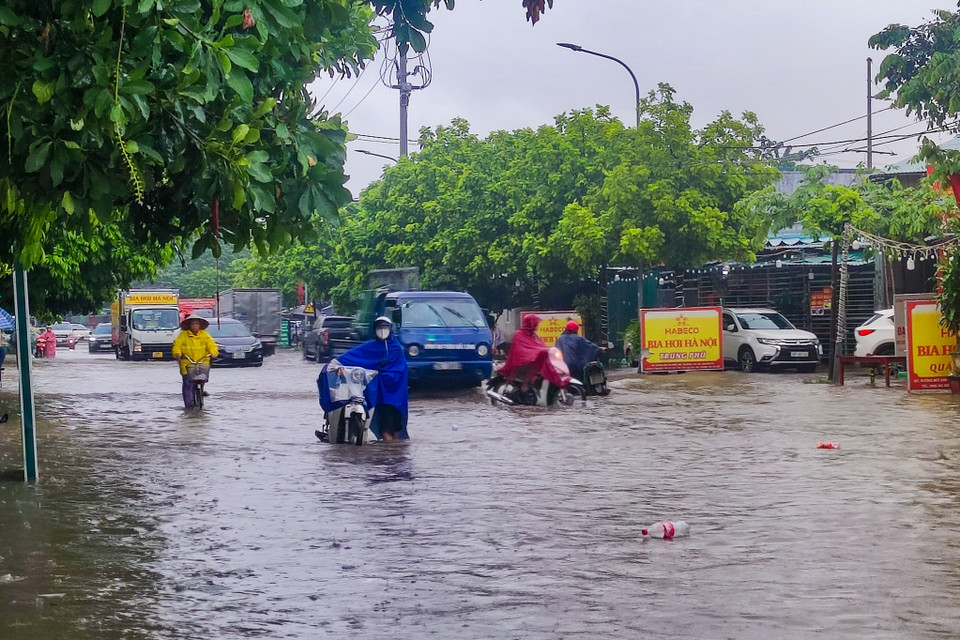 Ghi nhận của phóng viên Báo Điện tử VietnamPlus tại tuyến đường Tân Triều và Tân Triều mới huyện Thanh Trì, những con đường biến thành sông, mênh mông toàn nước và rác thải trôi lềnh bềnh. (Ảnh: Hoài Nam/Vietnam+)
