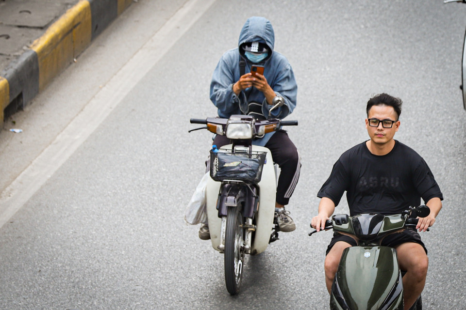 Thậm chí còn buông cả hai tay để để sử dụng điện thoại. (Ảnh: Hoài Nam/Vietnam+)