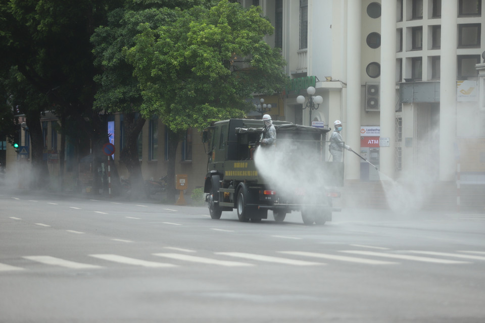  Với nhà cao tầng, ngõ nhỏ sẽ dùng dây kéo dài hoặc phương tiện cá nhân để phun khử khuẩn. (Ảnh: Hoàng Đạt/Vietnam+)