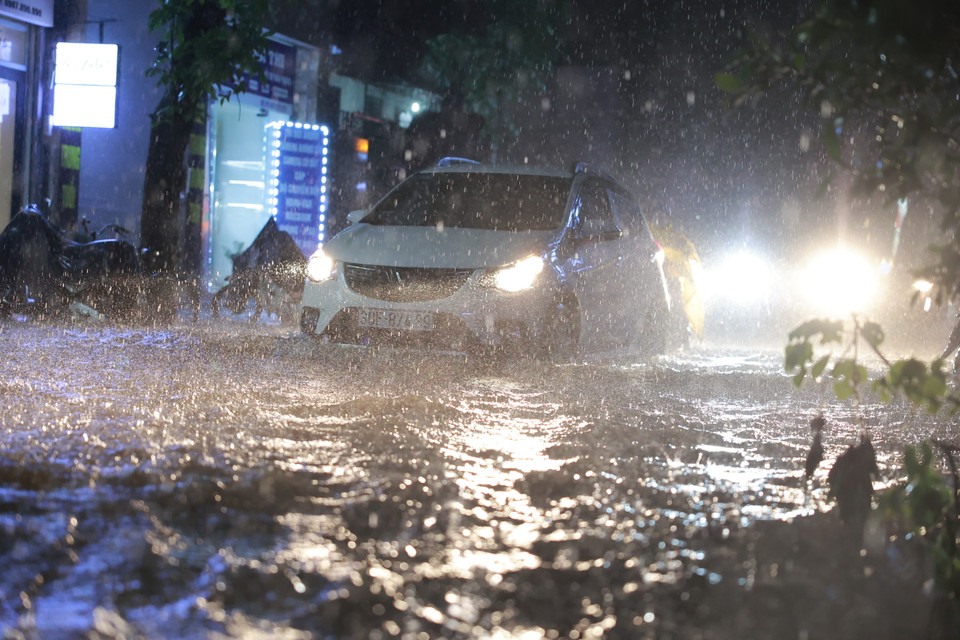Xe ôtô phải di chuyển rất cẩn thận qua những đoạn bị ngập sâu. (Ảnh: Minh Sơn/Vietnam+)