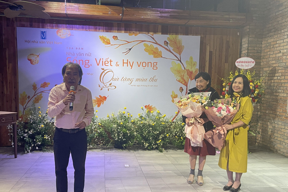 Chủ tịch Hội Nhà văn Việt Nam Nguyễn Quang Thiều chúc mừng các tác giả nữ. (Ảnh: PV/Vietnam+)