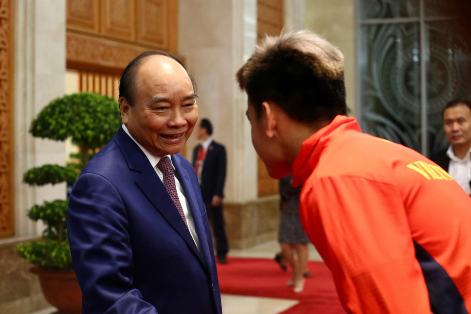 Thủ tướng Nguyễn Xuân Phúc chúc mừng cầu thủ Hồ Tấn Tài. (Ảnh: Nguyên An/Vietnam+)