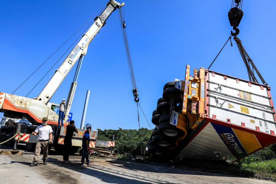 Hiện tổ công tác Đội CSGT số 14 vẫn đang khám nghiệm hiện trường, phân luồng giao thông, hỗ trợ cẩu kéo phương tiện gặp nạn. (Ảnh: Thành Đạt/TTXVN)