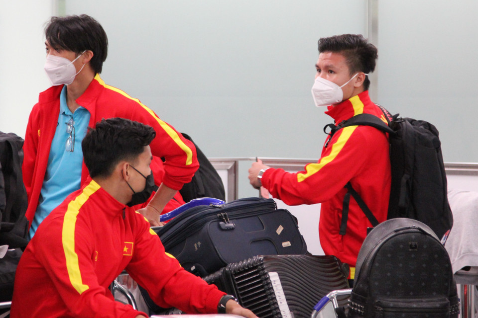 Các tiền vệ Quang Hải và Tuấn Anh đang chờ lên xe buýt ở sân bay. (Ảnh: Đào Thanh Tùng/TTXVN)