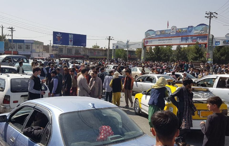 Người dân chen chúc nhau ngồi ở dưới đường băng, sân bay quốc tế Kabul.(Nguồn: AFP)