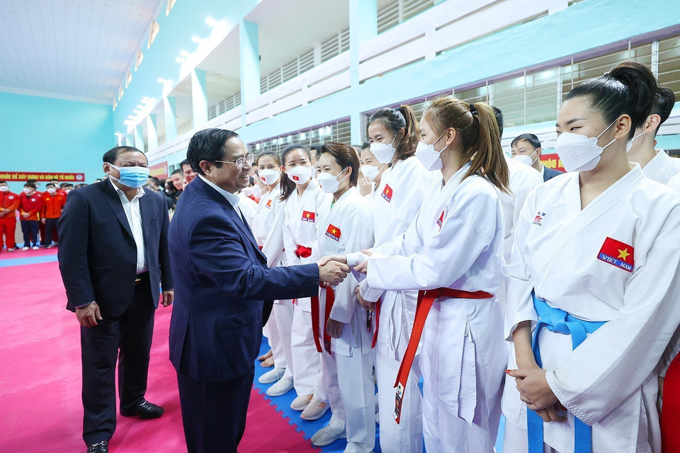 Thủ tướng Phạm Minh Chính động viên các huấn luyện viên và vận động viên đang tập luyện chuẩn bị tại Trung tâm Huấn luyện thể thao quốc gia.(Ảnh: Dương Giang/TTXVN)