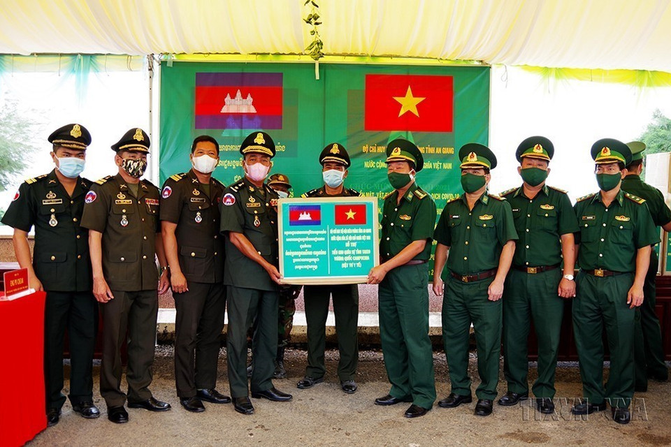 Đại tá Phạm Văn Phong, Chính ủy Bộ đội Biên phòng tỉnh An Giang trao biểu trưng quà tặng gồm tiền mặt và vật tư y tế phòng, chống dịch COVID-19 cho lực lượng Tiểu khu Quân sự tỉnh Takeo, Campuchia. (Ảnh: Công Mạo/TTXVN)