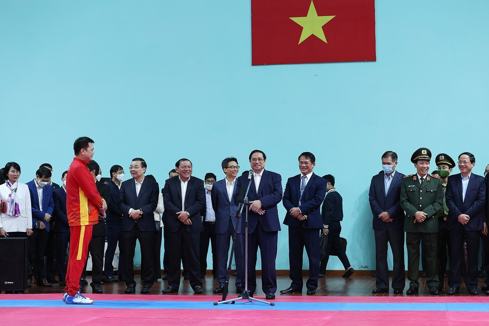 Thủ tướng Phạm Minh Chính động viên các huấn luyện viên và vận động viên đang tập luyện chuẩn bị tại Trung tâm Huấn luyện thể thao quốc gia. (Ảnh: Dương Giang/TTXVN)