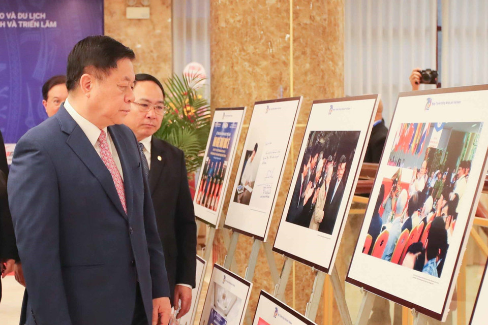 Đồng chí Nguyễn Trọng Nghĩa, Bí thư Trung ương Đảng, Trưởng Ban Tuyên giáo Trung ương cùng các đại biểu tham quan trưng bày ảnh tại lễ kỷ niệm. (Ảnh: Thanh Tùng/TTXVN)
