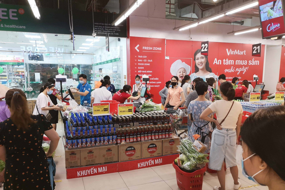 Người dân đi mua sắm tại siêu thị VinMart Times City trong sáng 24/7. (Ảnh: Thanh Tùng/TTXVN)