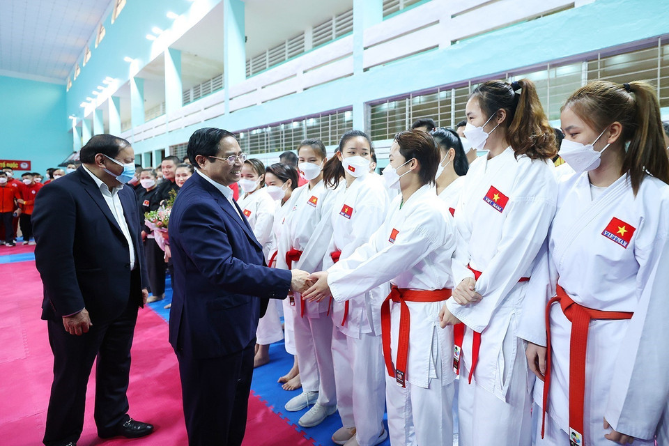 Thủ tướng Phạm Minh Chính động viên các huấn luyện viên và vận động viên đang tập luyện chuẩn bị tại Trung tâm Huấn luyện thể thao quốc gia.(Ảnh: Dương Giang/TTXVN)