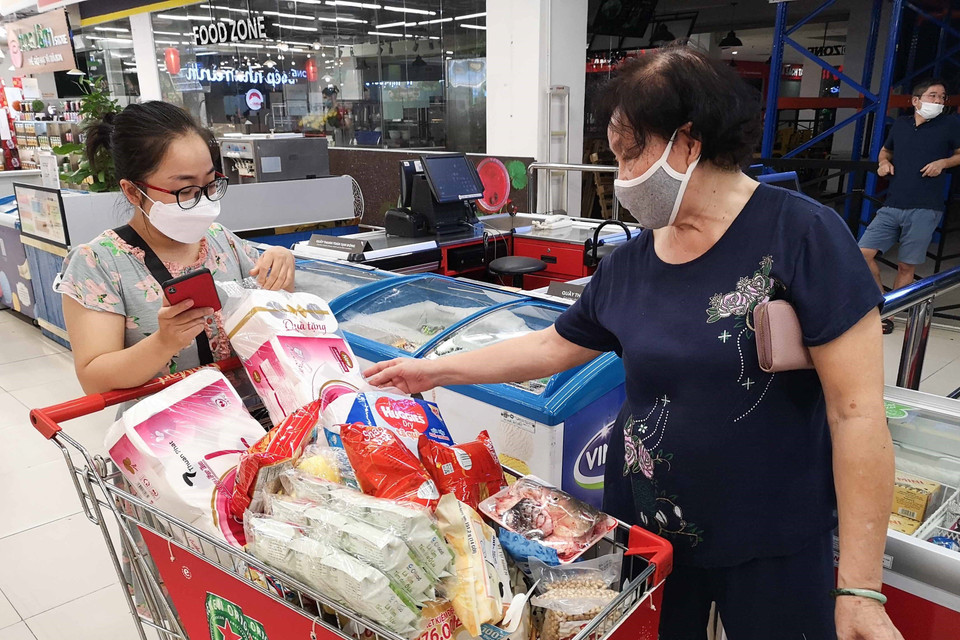 Nhiều người do tâm lý không tốt đã mua nhiều đồ tại siêu thị VinMart Times City trong sáng 24/7 để tích trữ. (Ảnh: Thanh Tùng/TTXVN)